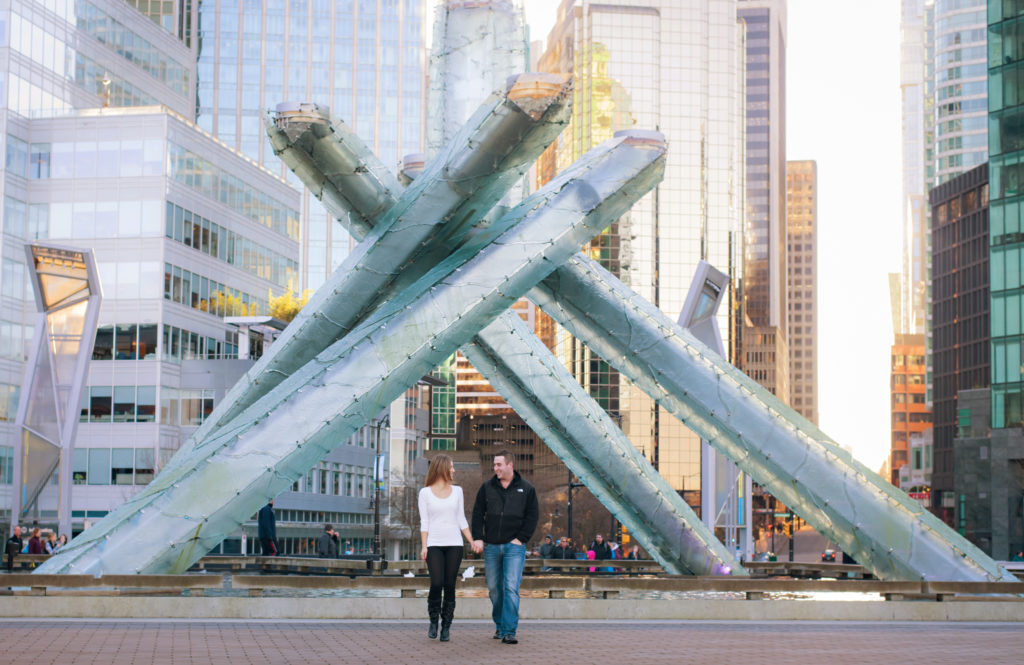 Couple at Olympic cauldron in Vancouver walking hand in hand